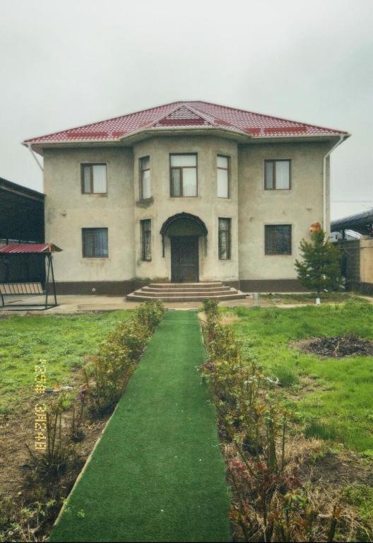 ein großes Haus mit einem Weg davor in der Unterkunft Гостевой дом с 7 комнатами in Schymkent