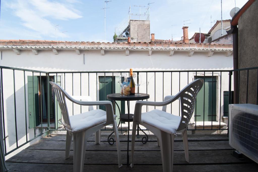 a patio with two chairs and a table on a balcony at Santa Maria Formosa in Venice