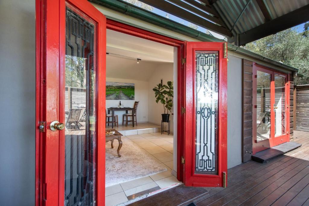 eine offene rote Tür an einem Haus mit Veranda in der Unterkunft Petersons Wines Dairy Cottage in Pokolbin