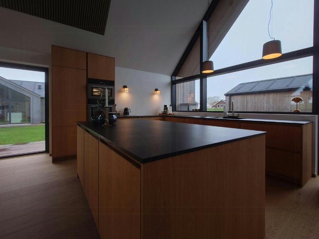 een grote keuken met een zwart aanrecht bij Modern Villa By Ballen Marina On Samsø in Ballen