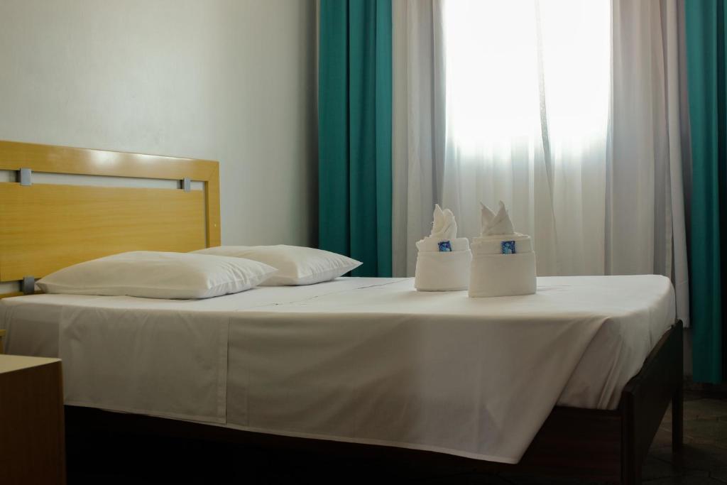 a bed with two towels on top of it at Cracco Park Hotel in Curitiba