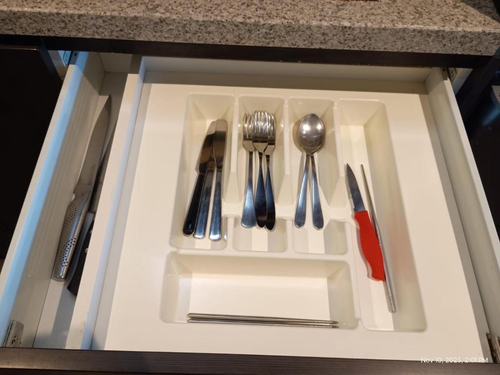 a drawer with utensils sitting on a white tray at Cozy 1 Bed Apartment - 2 Min to Queen VIC Market in Melbourne
