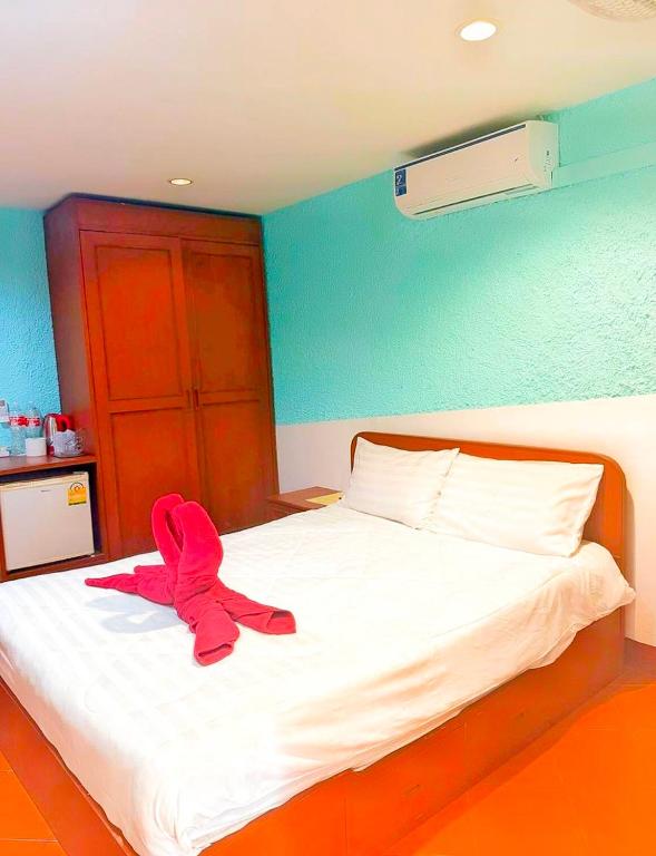 a pink stuffed animal sitting on a bed at Suki Palm in Ban Bang Chak
