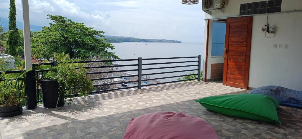 a balcony with a view of a body of water at Amed Sari Beach Guesthouse in Amed