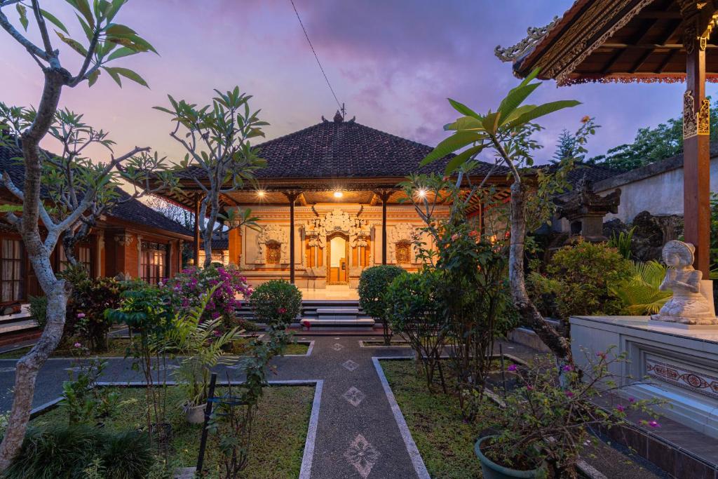 an exterior view of a house with trees and plants at Jiwandari House Bali in Darmasaba