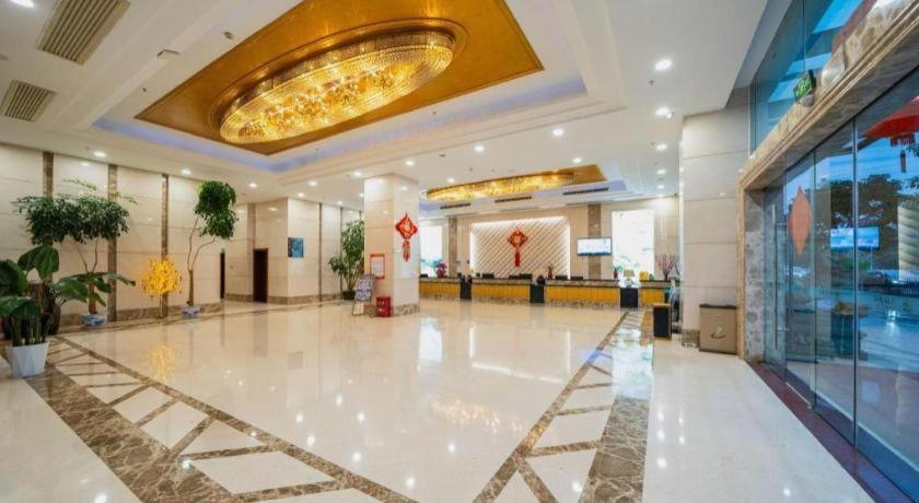 a large lobby with a large white floor and a large ceiling at Bashan Hotel in Xiamen