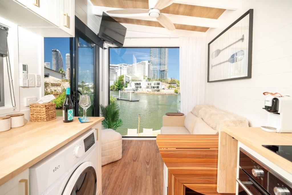 a kitchen and living room with a view of the water at Tiny Home in the heart of Broadbeach-River Views! in Gold Coast