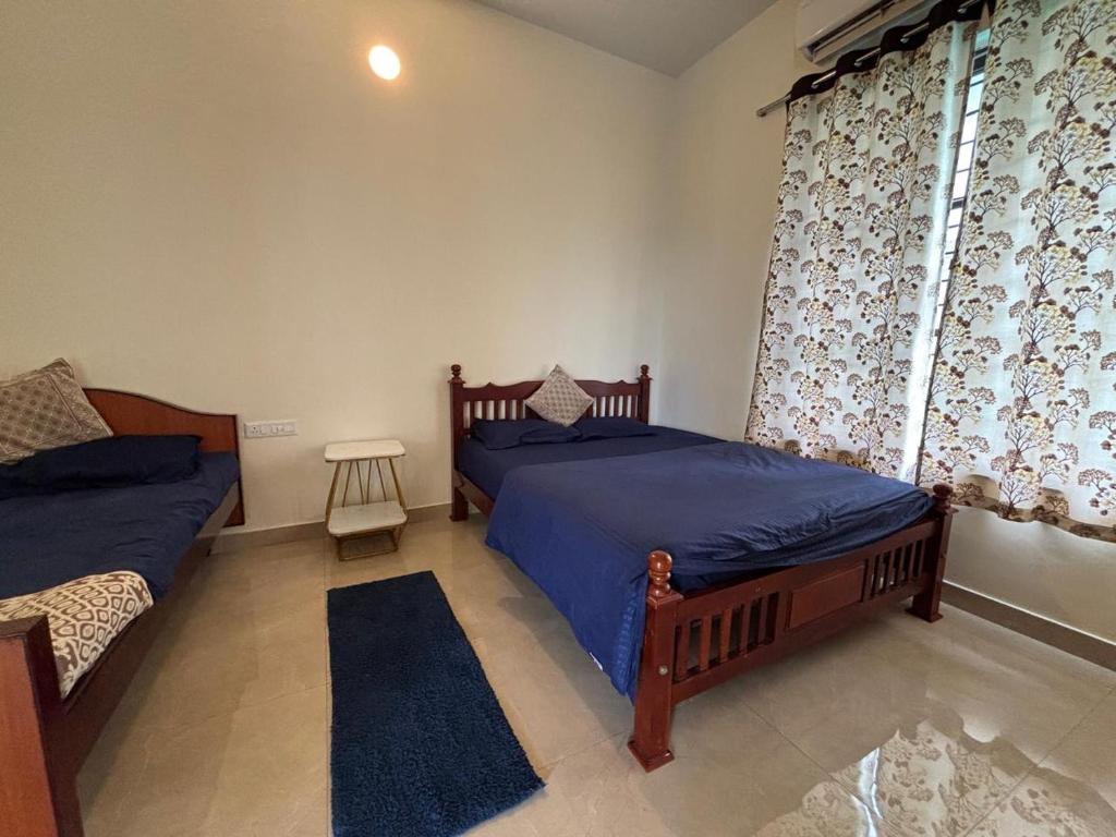 a bedroom with two beds and a window at VINTAGE VISTA RESORTs in Chennai