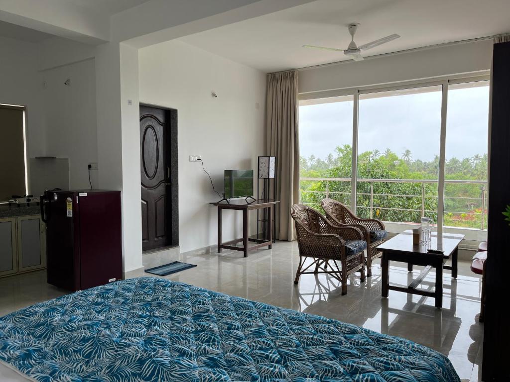 Un dormitorio con una cama y una mesa y sillas. en The Ashvem Horizon, en Mandrem