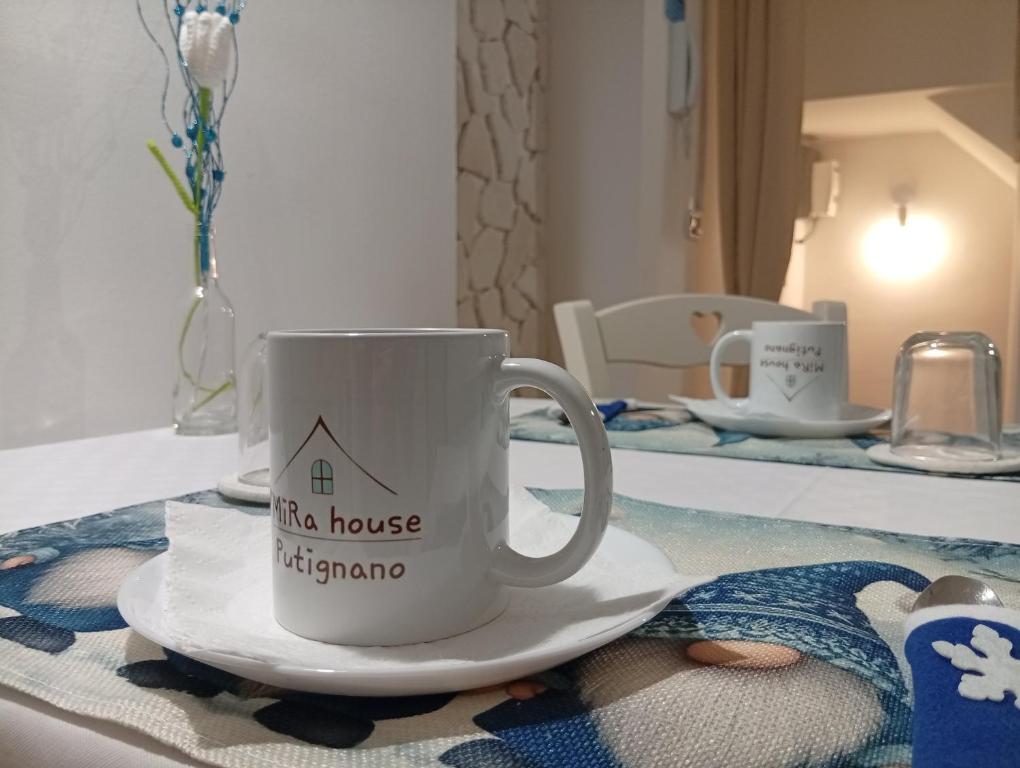eine Kaffeetasse auf einem Teller auf einem Tisch in der Unterkunft CV MiRa house in Putignano
