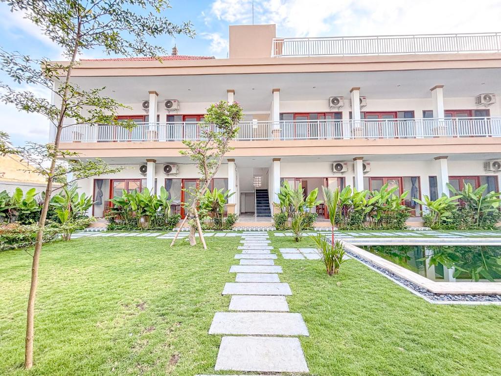 une maison avec un jardin devant dans l'établissement Oemah Maha, à Tanah Lot