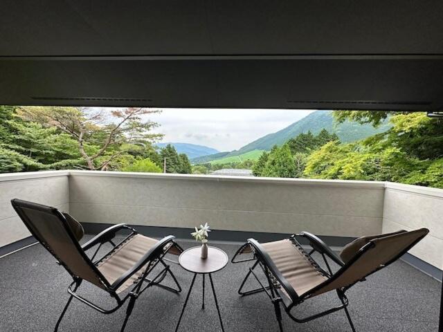 two chairs and a table on a balcony with a view at Hakone Villa with your private hot spring! in Hakone