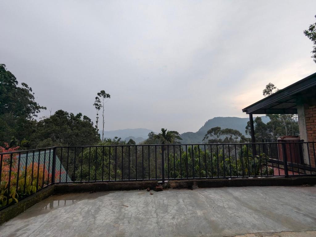 a balcony with a fence and mountains in the background at New Green View Guest House Kithal Ella in Badulla