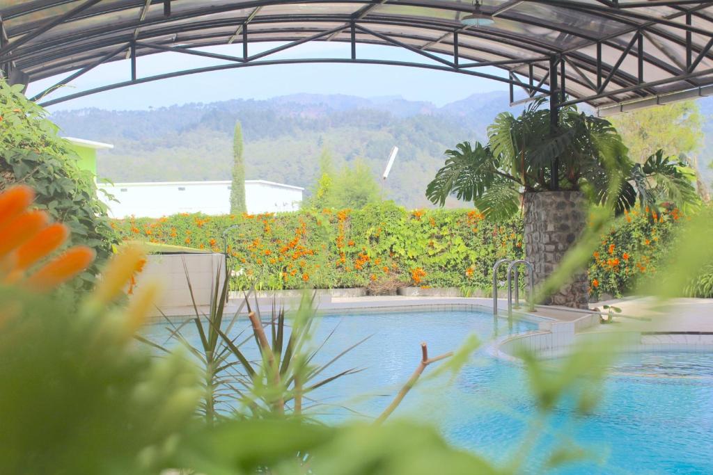 a swimming pool in a garden with flowers at De View Hotel By PRO in Punten