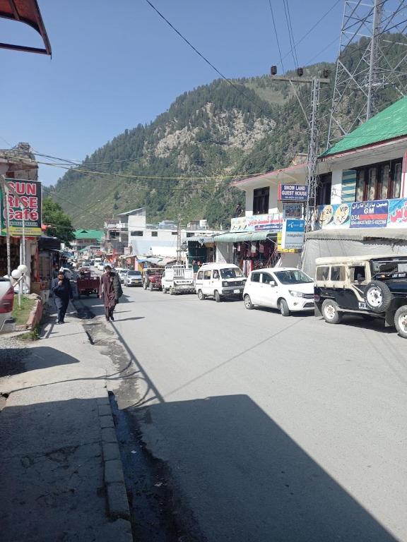 a street with cars parked on the side of the road at Moon Rise Hotel in Dargai