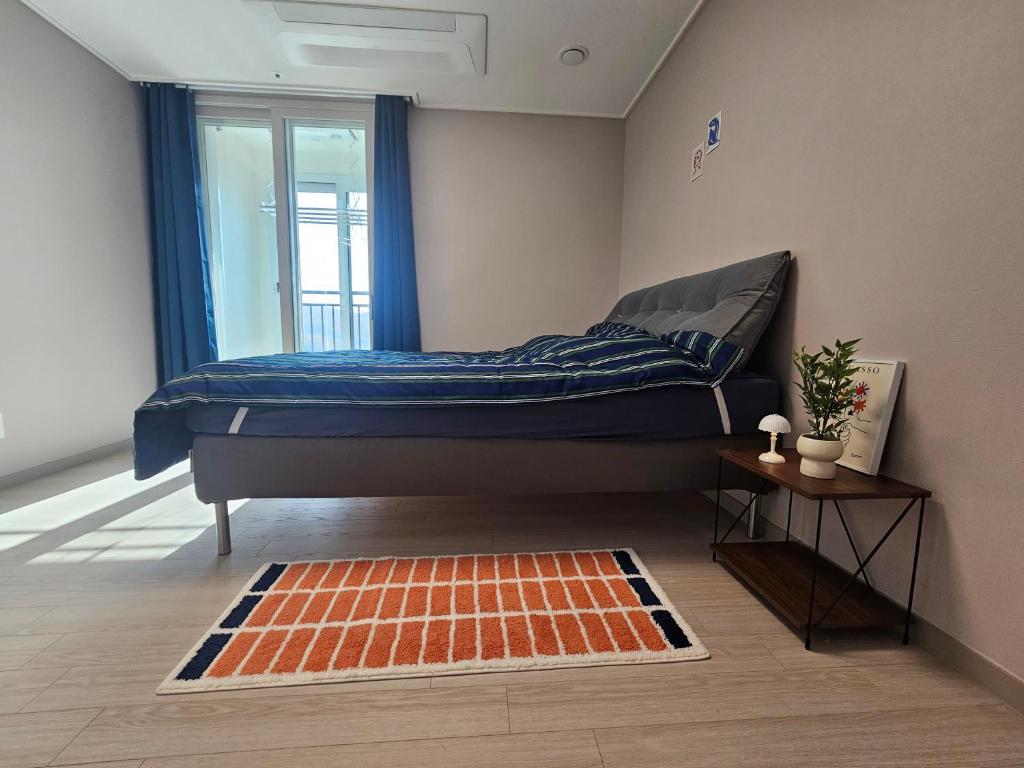 a bedroom with a bed with a window and a rug at Indeogwon stay 27 in Mabun-ni
