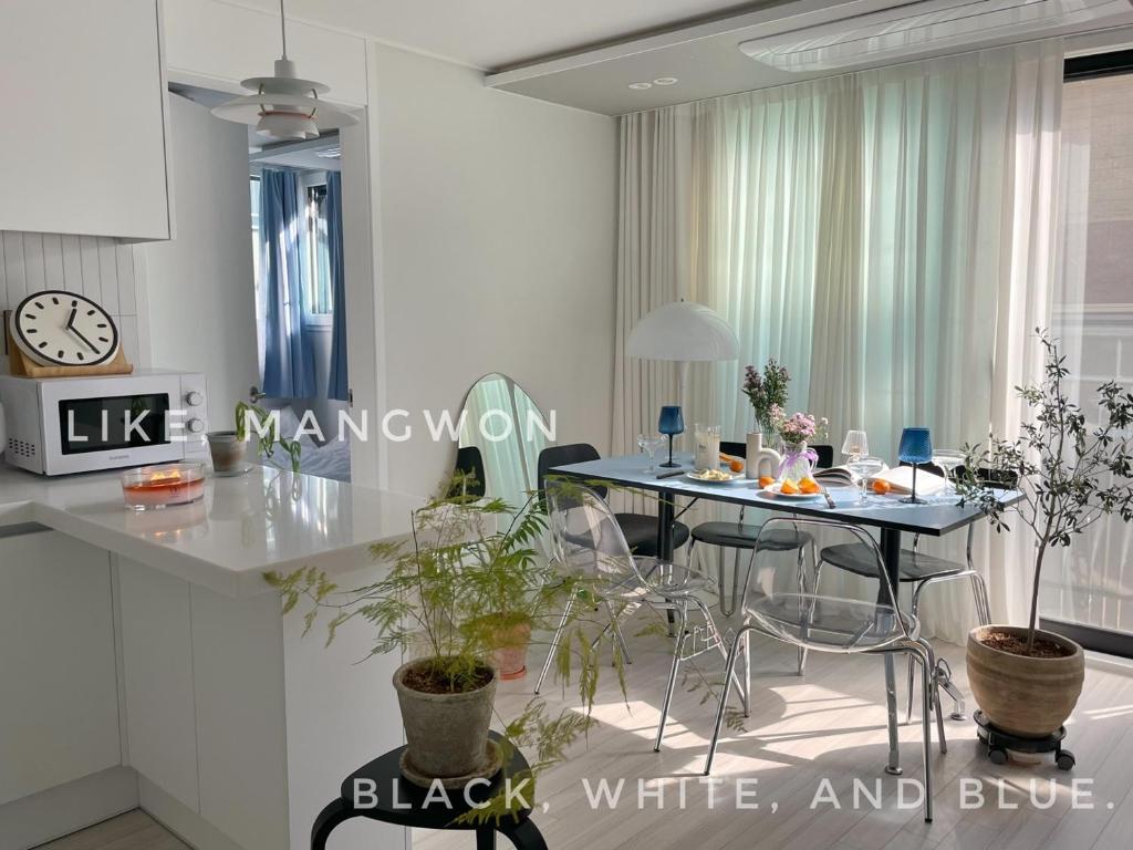 a kitchen with a table and chairs and a clock at LIKE Mangwon in Seoul