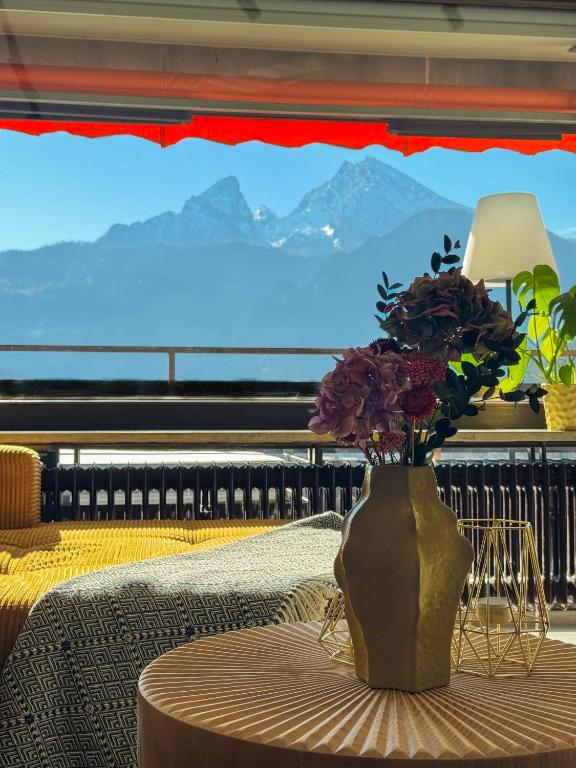 a vase with flowers sitting on a table with a view at Watzmann Juwel in Berchtesgaden