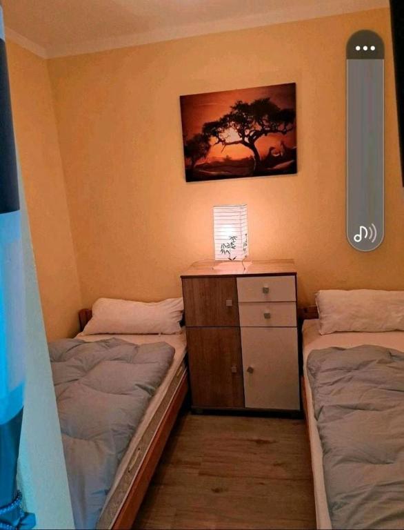 ein Schlafzimmer mit zwei Betten und einer Kommode mit Lampe in der Unterkunft Ferienwohnung Relax 5 in Hahnenklee-Bockswiese