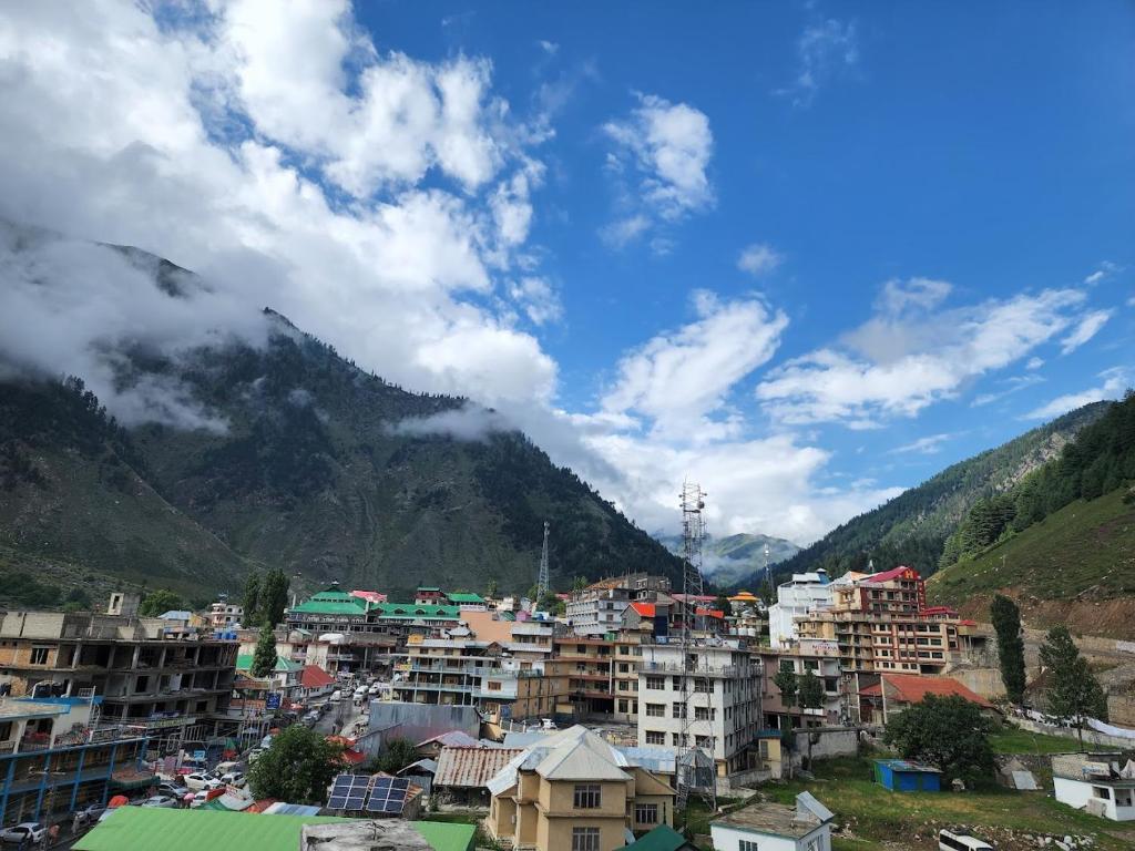 Una vista de una ciudad con montañas al fondo. en Hotel Emerlad Crown, en Dargai