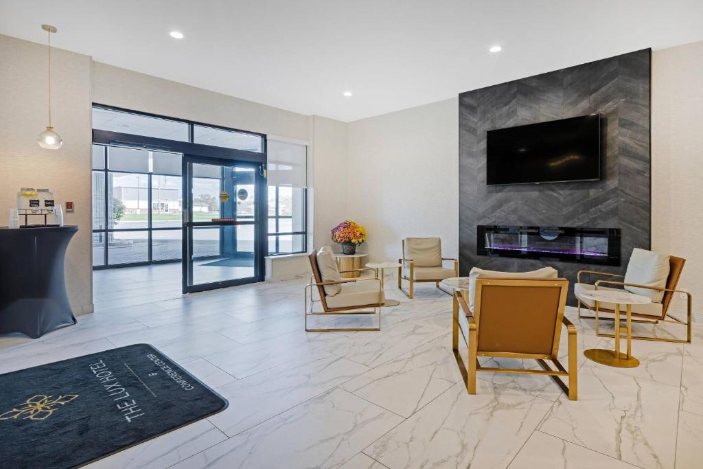 een woonkamer met open haard en tv bij The Lux Hotel & Conference Center, an Ascend Collection Hotel in Waterloo
