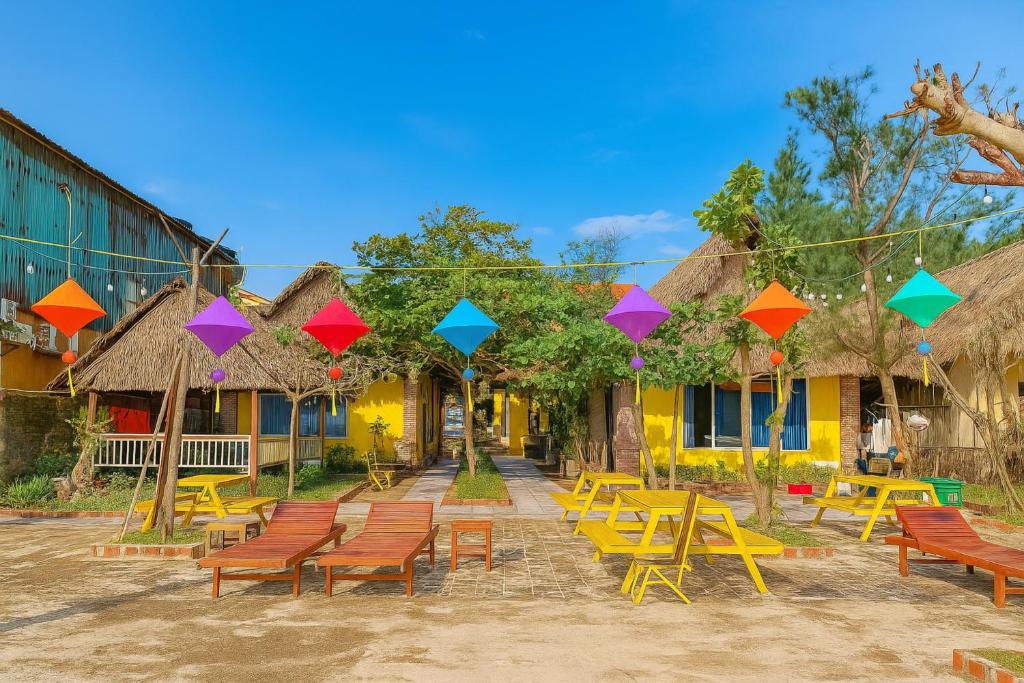 a group of tables and chairs in front of buildings at Newlife Homestay in Dong Hoi