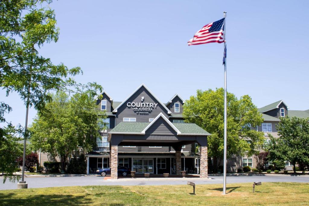 an american flag flying in front of a hotel at Country Inn & Suites by Radisson, Carlisle, PA in Carlisle