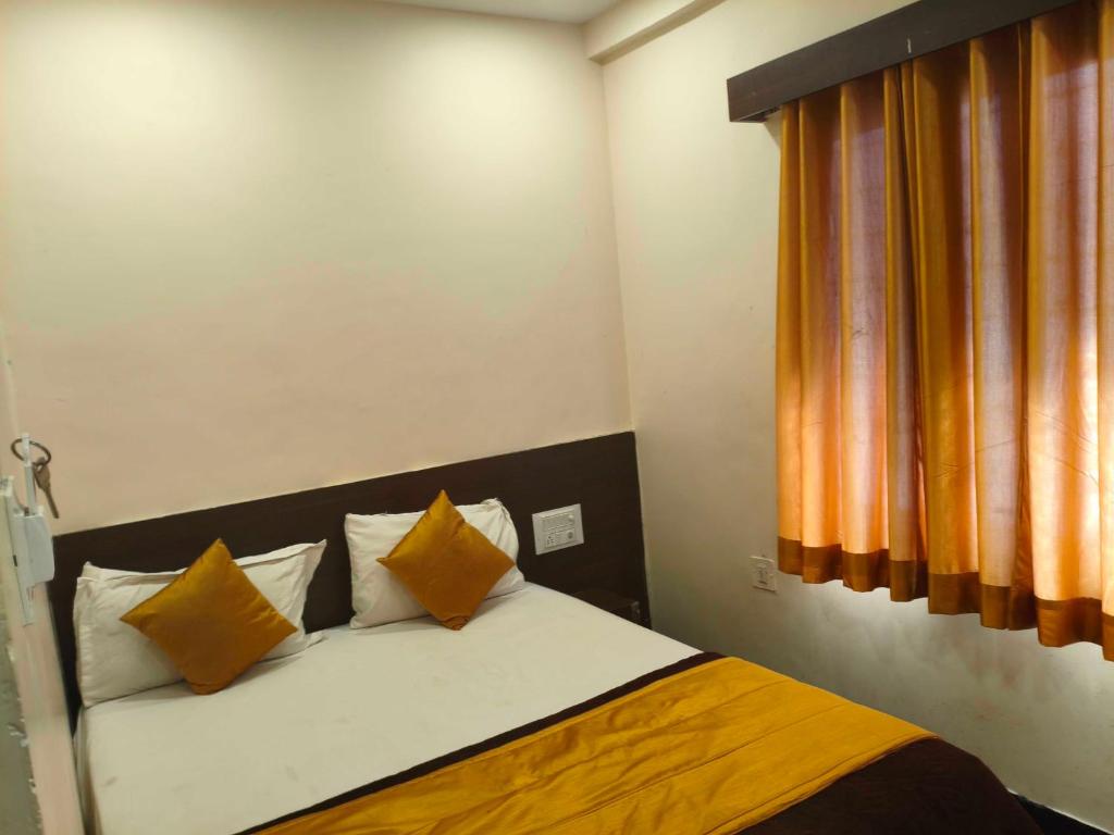 a bedroom with a bed with orange and white pillows at Hotel O Laxmi Narsimha Temple Banjara Hills in Hyderabad