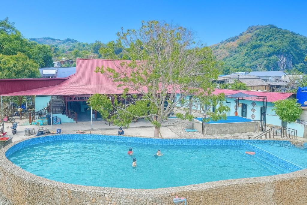a pool at a resort with people in the water at Giáp Hoài Homestay Suối Khoáng Nóng Bản Hốc in Yên Bái
