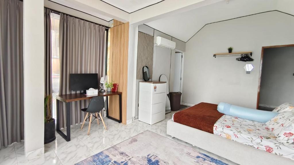 a bedroom with a bed and a desk at Villa Dalia Puncak NA6-12 in Cimacan
