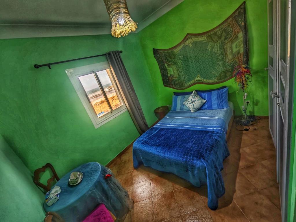 a bedroom with a bed in a green room at Ocean Hideaway - Sea View in Essaouira
