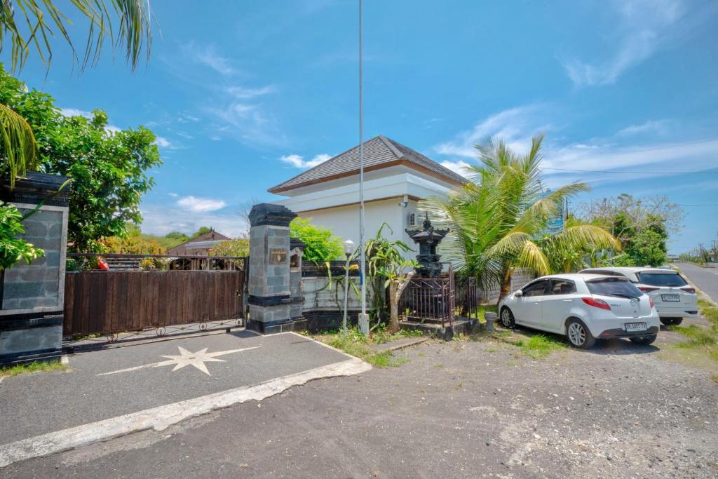 a white car parked in front of a house at Moringa Pandawa Guest House in Ungasan