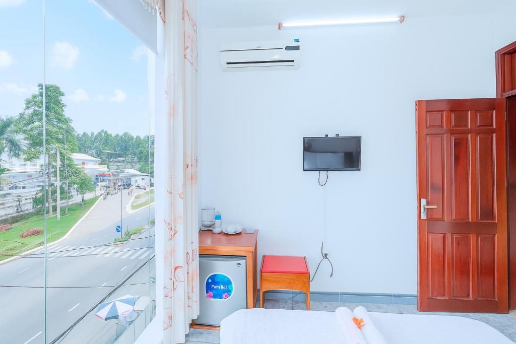 a living room with a window and a tv at Phú Vang Hotel Pleiku in Pleiku