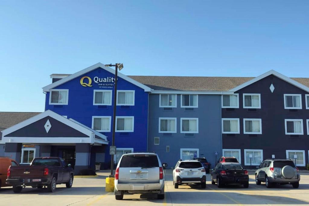 a large blue building with cars parked in a parking lot at Quality Inn & Suites Bethany in Bethany