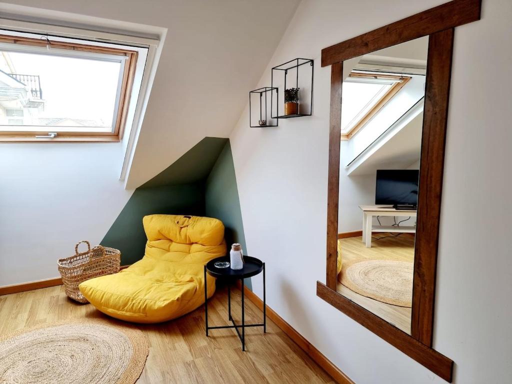 a yellow chair in a room with a mirror at Vila, 132 - II in San Cosme de Barreiros