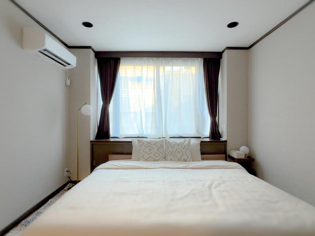 a bedroom with a large bed with a window at MANDO Hotel 101 in Tokyo