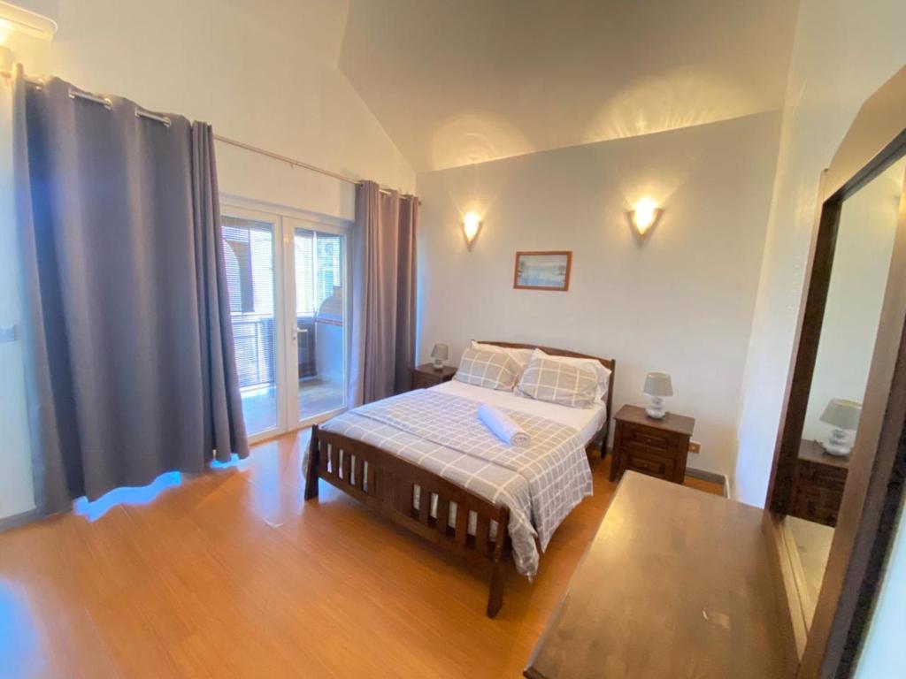 a bedroom with a bed and a large window at Grand Bay 4Bed Triplex Villa with Community Pool in Grand Baie
