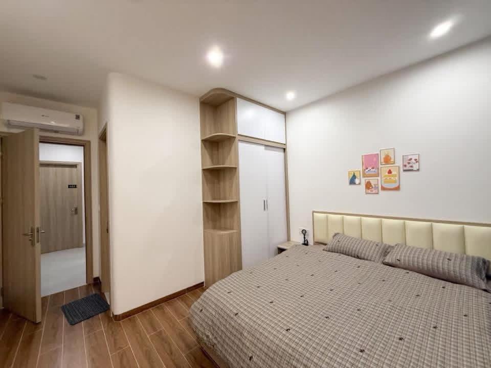 ein Schlafzimmer mit einem Bett und einem Bücherregal in der Unterkunft Creamy home - Homestay Vinhomes Ocean Park 3 in Ðình Loan