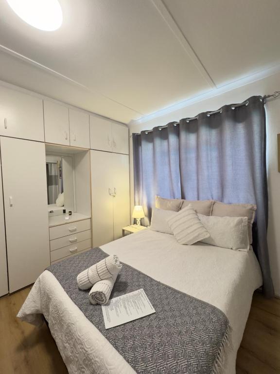 a bedroom with a bed with two towels on it at Mario & Luiza's Place - Cozy Stay with Pool & Braai in Worcester