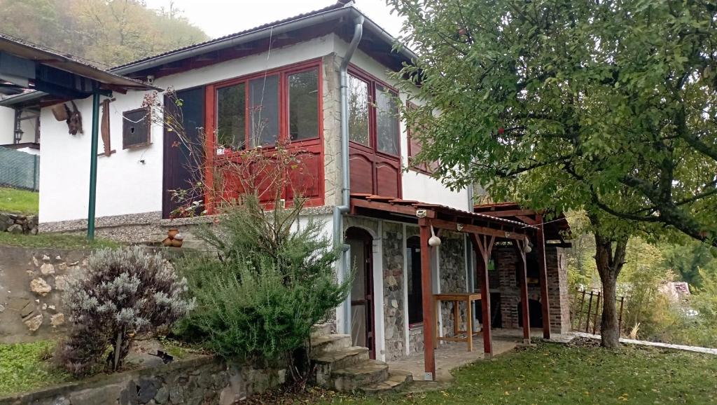 una casa con una casa roja y blanca en Vila Hedona, en Donji Milanovac