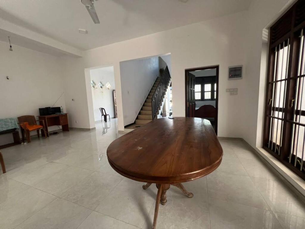 - un salon avec une table en bois et un escalier dans l'établissement Charming Retreat, à Matara