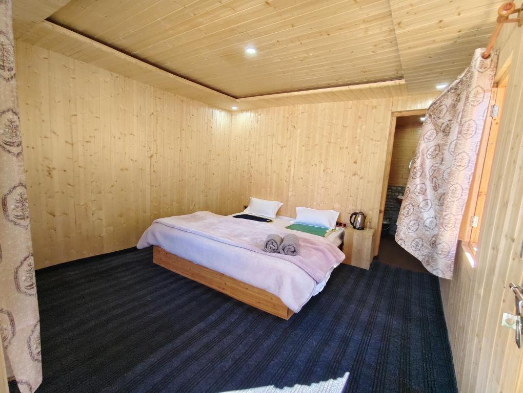 ein Schlafzimmer mit einem Bett in einem Holzzimmer in der Unterkunft Outback Cottages and Camps in Saturang