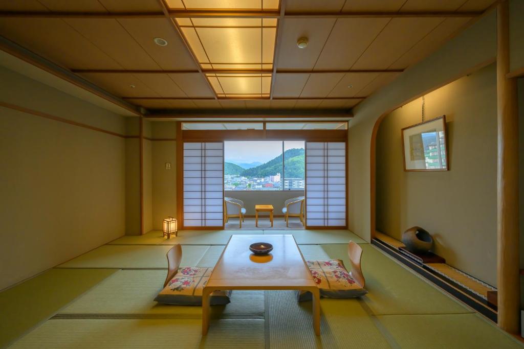 une pièce avec une table, des chaises et une fenêtre dans l'établissement Tendo Hotel, à Tendō 74 autres photos