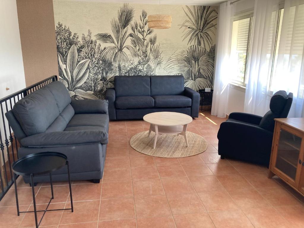 Domaine de la Brugaye Mimosa في Saint-Cézaire-sur-Siagne: غرفة معيشة مع أريكة وطاولة