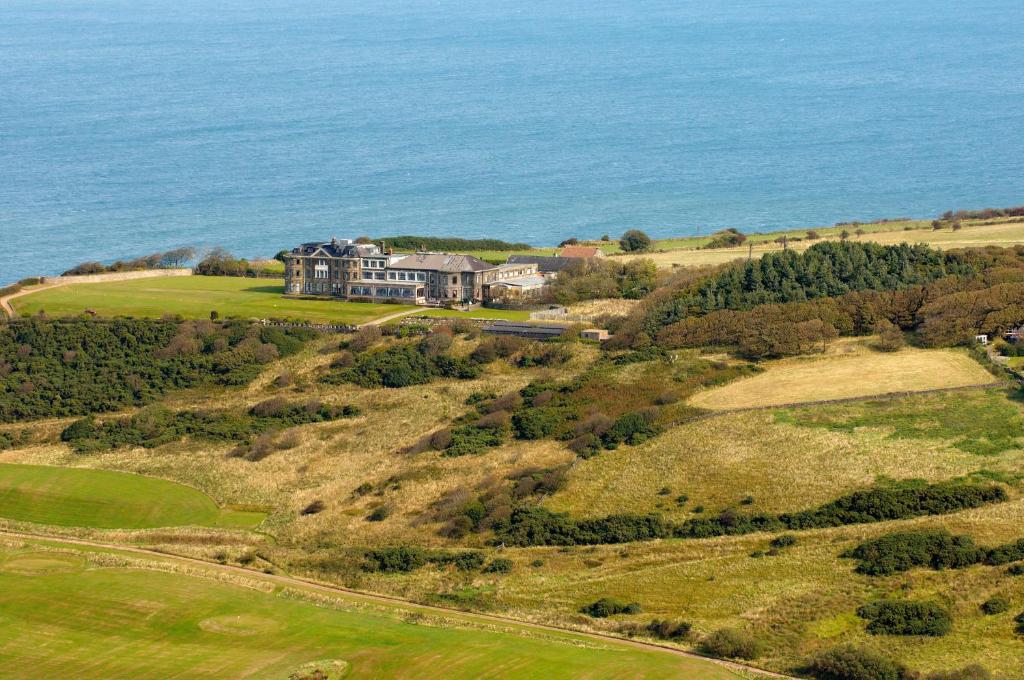 - une vue aérienne sur une maison située sur une colline à côté de l'océan dans l'établissement Grand Villa Heights, à Ravenscar