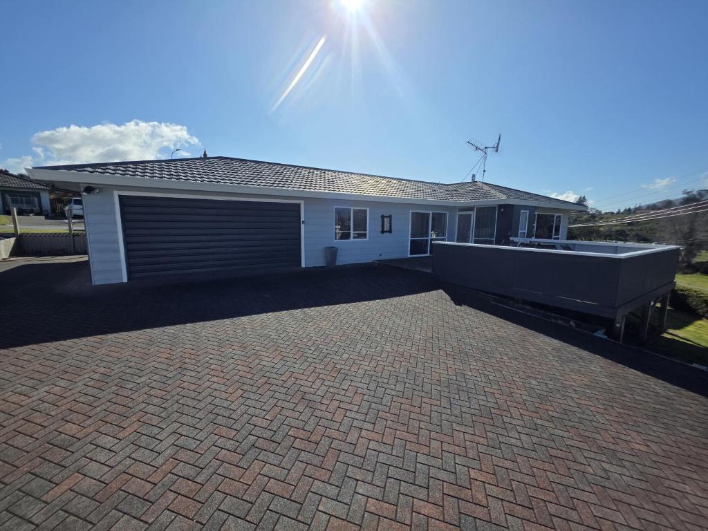 a house with a brick driveway in front of it at The Retreat Taupo in Taupo