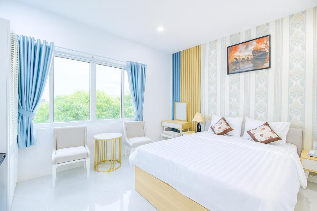 a white bedroom with a large bed and a window at Hoàng Gia Hotel Royal in Kim Bảng