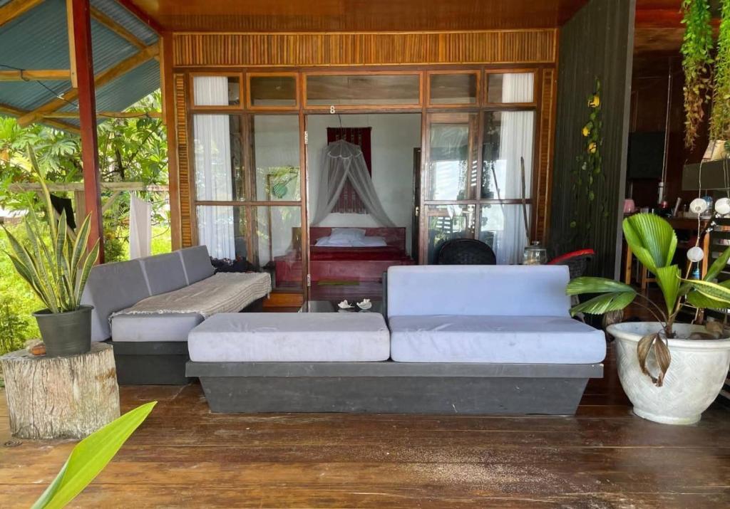 Savana Cottages في Letman: غرفة معيشة بها أريكة بيضاء وبعض النباتات