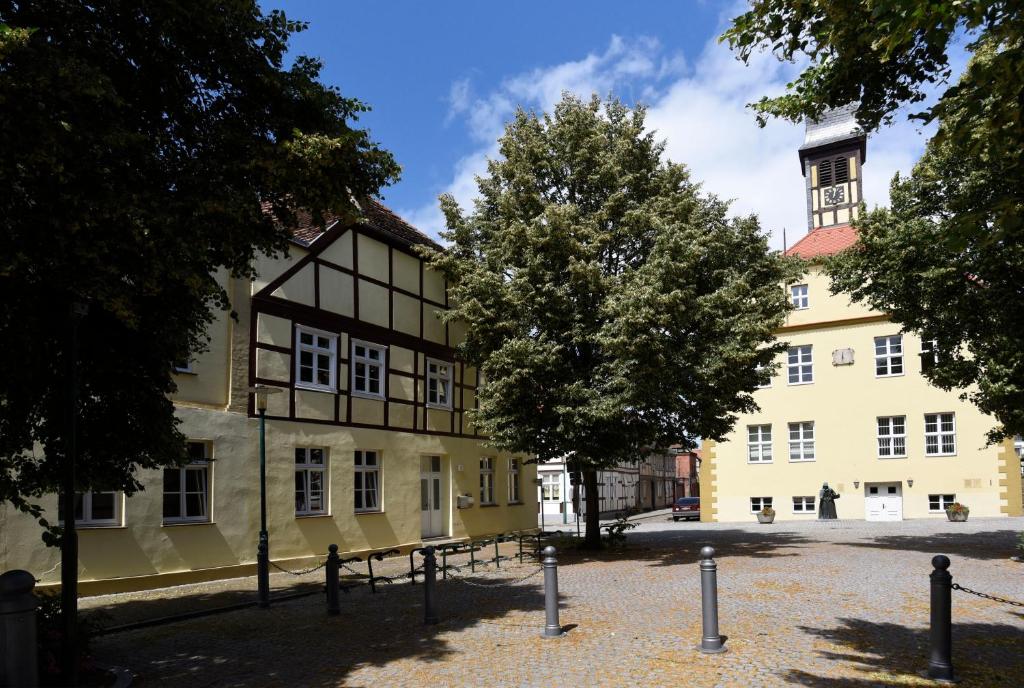ein altes Gebäude mit einem Baum davor in der Unterkunft Zur Hauptwache - Lenzen (Elbe) in Lenzen