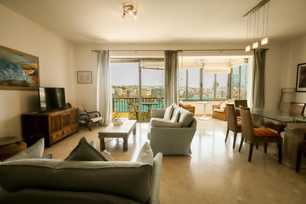 Una sala de estar con sofás y sillas y una mesa. en Waterfront Panorama Massive Three Bedrooms Flat 8S, en Sliema